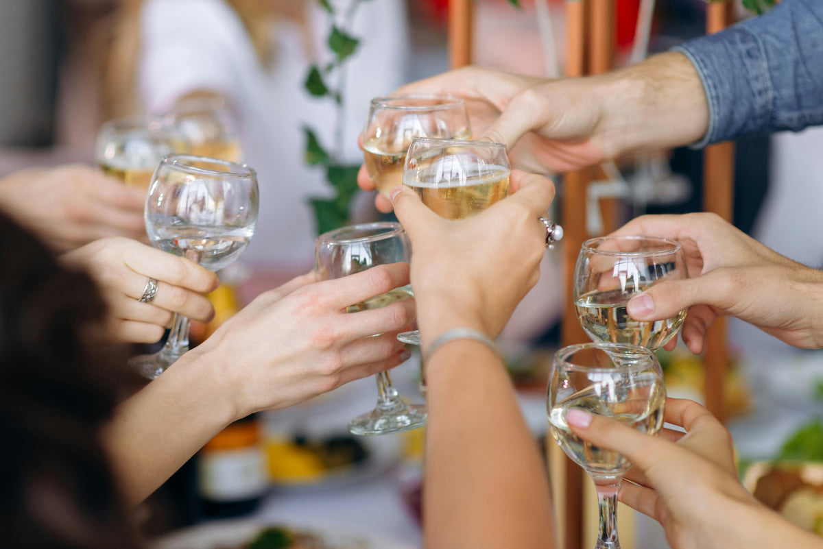 Wedding guests toasting with sparkling non-alcoholic drinks at an event bar