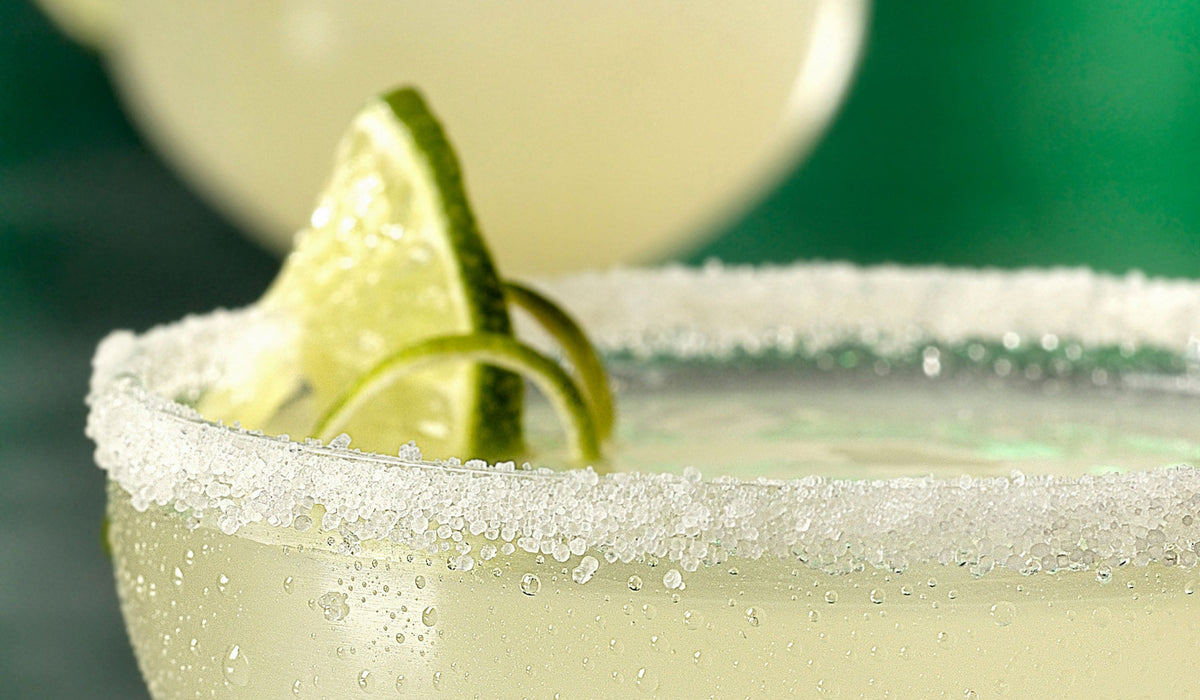 Non-alcoholic spicy margarita mocktail with chili-salt rim and jalapeno slice